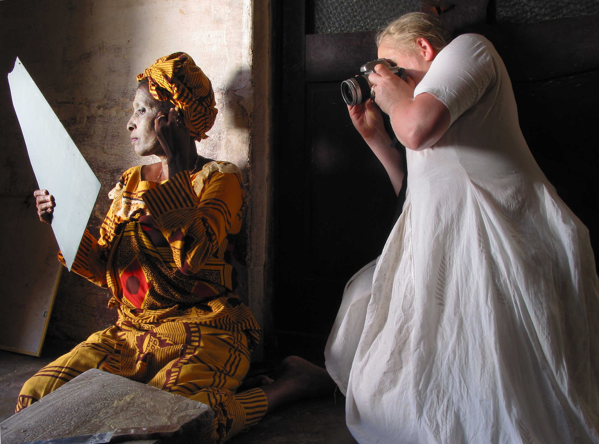 Making-of photograph showing the photographer Magi Viljanen during a portrait session for the exhibition *Women*, documenting the process of staging and photographing the subject behind the scenes.