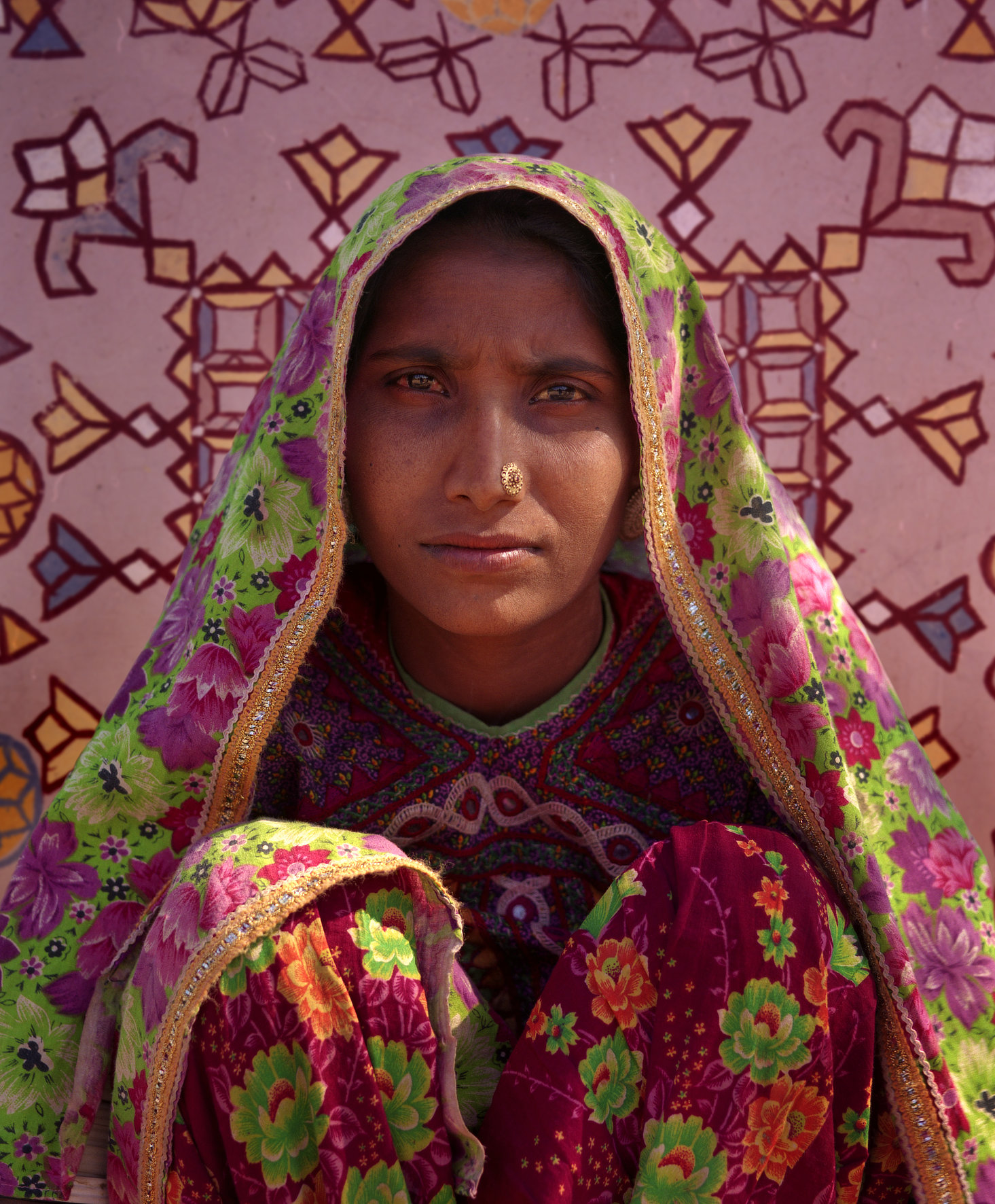 Portrait of a Rabari woman wearing a floral veil and traditional nose ornament in Kutch, Gujarat.