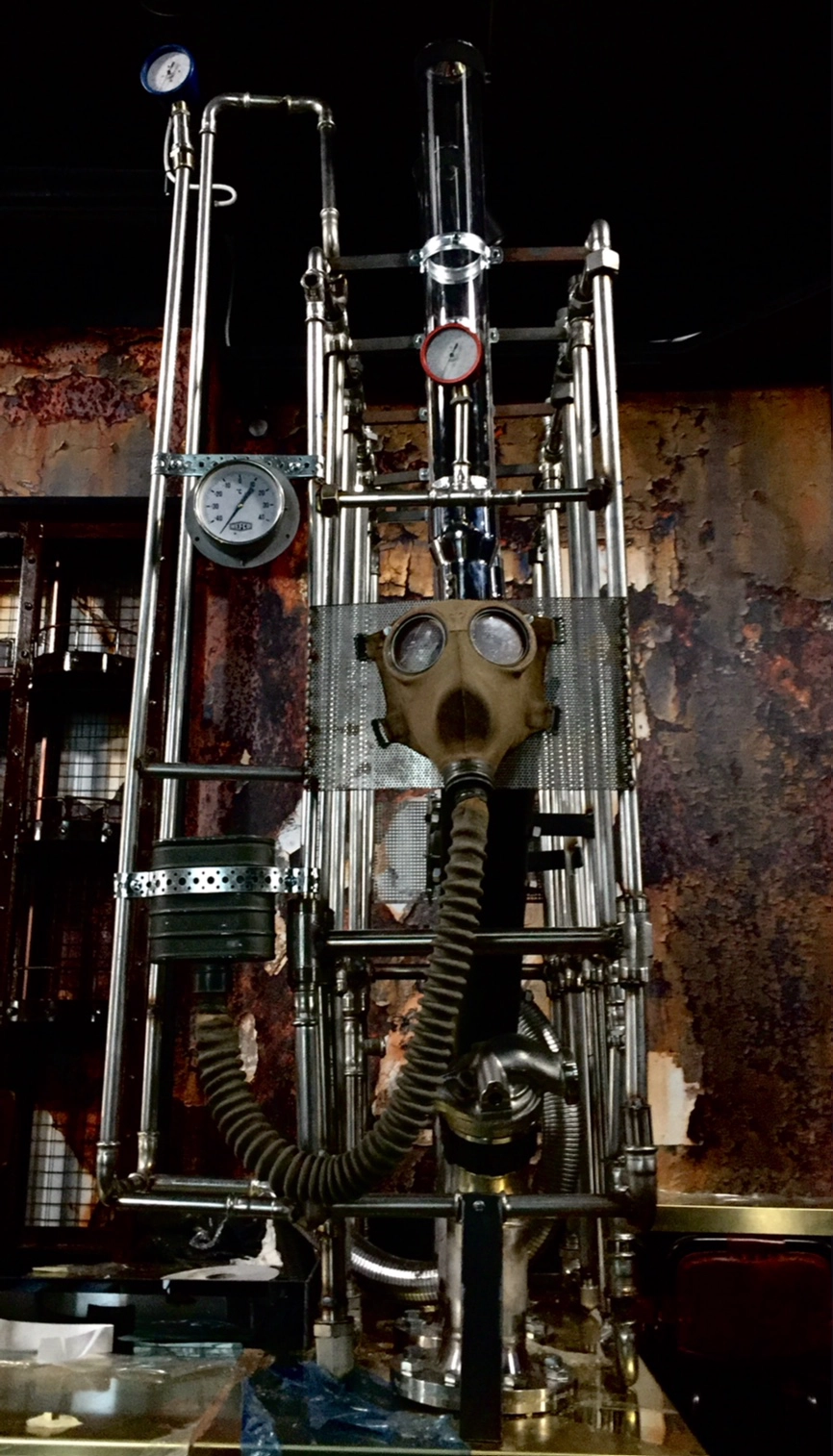 Machines from Hell by Magi Viljanen, a tall sculptural construction of pipes, gauges, glass cylinders and a gas mask.